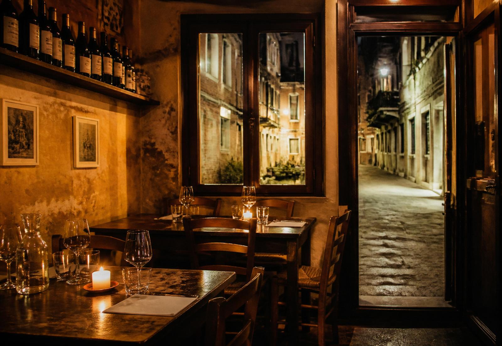 La sala dell'Osteria Bertoliana, tavoli in legno e candele accese